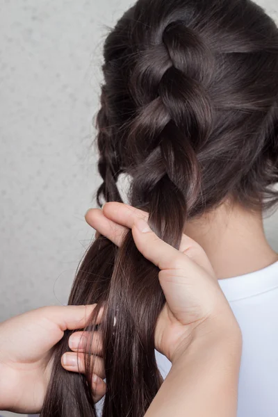 Väva fläta flicka i en frisörsalong — Stockfoto