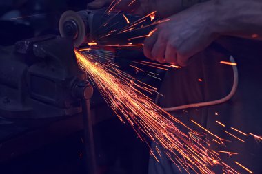 adam açı değirmeni ile metal kesme. Demir taşlama sırasında Sparks
