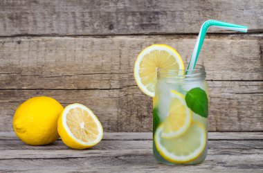 Ahşap arka plan üzerinde limonlu soğuk taze ev yapımı limonata