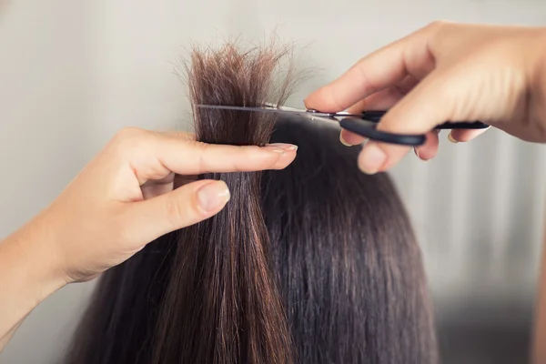 Парикмахер стрижет волосы женщины крупным планом — стоковое фото