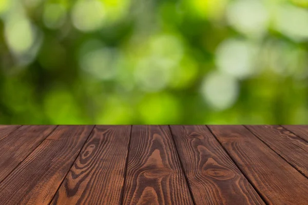 Mesa vacía de madera con jardín verde borroso —  Fotos de Stock