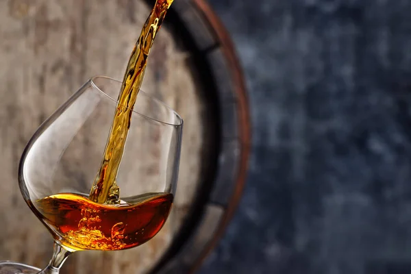 Cognac die in glas wordt gegoten — Stockfoto
