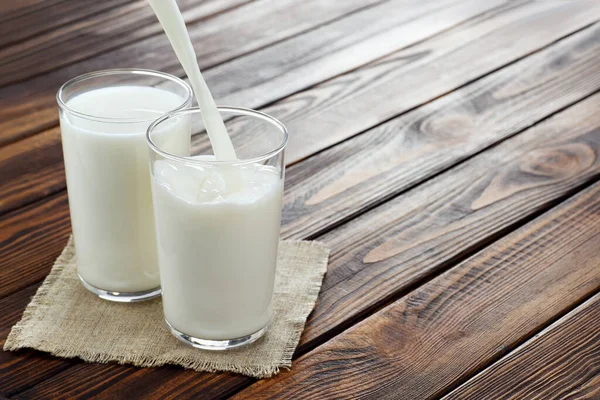 Milch ins Glas gießen — Stockfoto