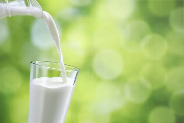 Melk die in glas wordt gegoten — Stockfoto