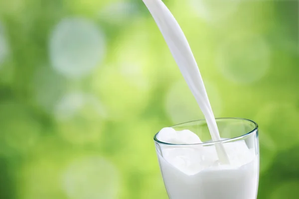Melk die in glas wordt gegoten — Stockfoto