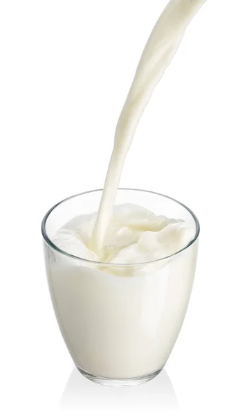 Susu menuangkan ke dalam gelas yang terisolasi di atas putih — Stok Foto