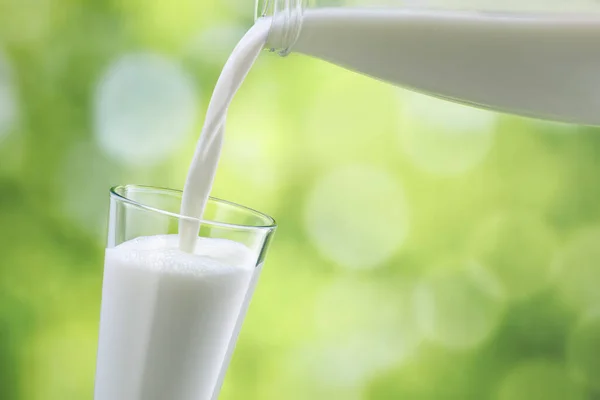 Milch ins Glas gießen — Stockfoto