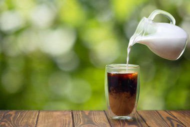 Uçan sürahiden kahve bardağına dökülen krema