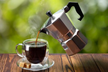 Uçan gayzer kahve makinesinden fincana espresso dökülüyor.