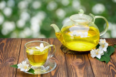 Cam bardak ve yeşil çaydanlık yasemin çiçekli.