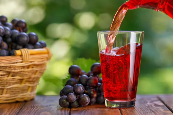 stock image grape juice pouring into glass from jug