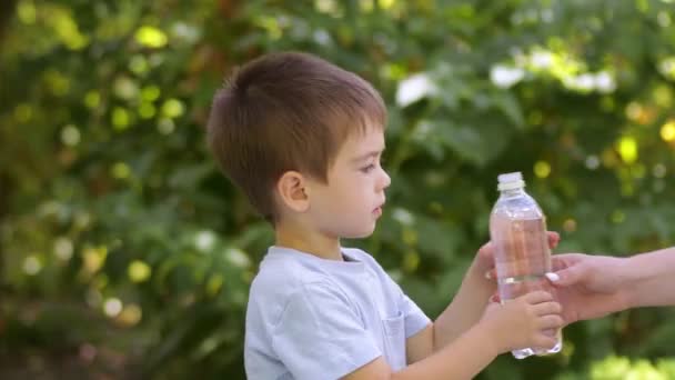 Roztomilý malý chlapec pití vody z plastové láhve venku — Stock video