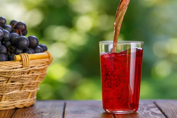 庭のテーブルの上にグラスに注ぐブドウジュース — ストック写真