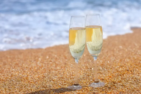 Dwa kieliszki szampana na plaży morskiej — Zdjęcie stockowe