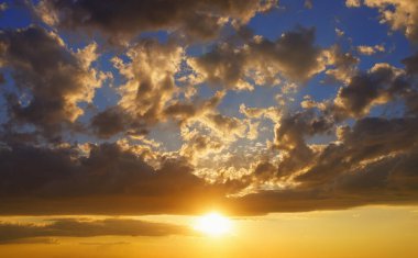 Bulutlu gökyüzü ve gün batımında batan güneş