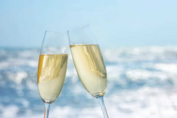 Két pohár pezsgő a tengerparton. — Stock Fotó