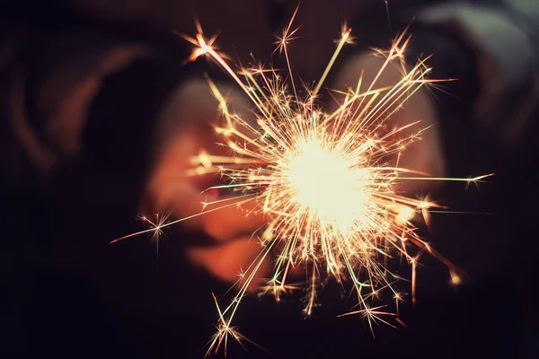 Beautiful sparkler in woman hands — Stock Photo, Image