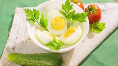 Maydanoz yapraklı ve domatesli bir kasede iki tavuk yumurtası. 