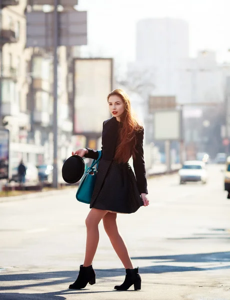 Belle femme à la mode dans un chapeau et manteau posant à l'extérieur dans une ville — Photo