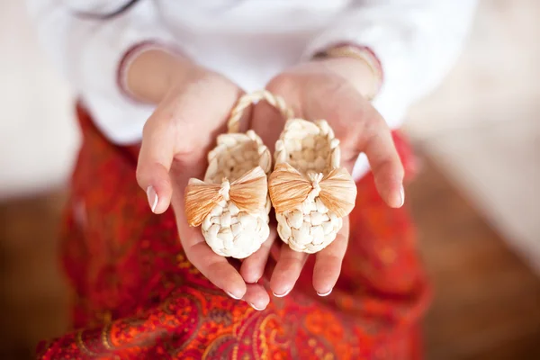 annenin avuç içlerinde küçük bebek ayakkabıları.