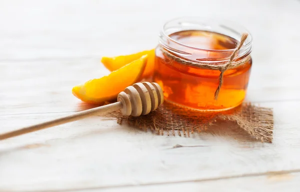 Bir kavanoz bal ve Turuncu Beyaz ahşap bir masa üzerinde