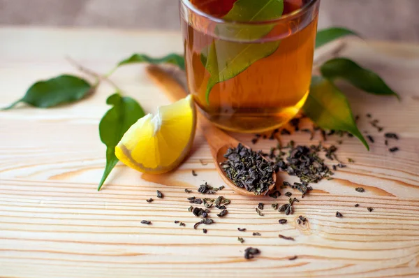 Taza de té con limón en una mesa de madera — Foto de Stock