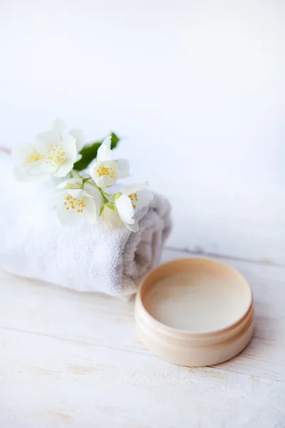 Perawatan kecantikan, bunga jasmin dan kosmetik di meja kayu putih — Stok Foto