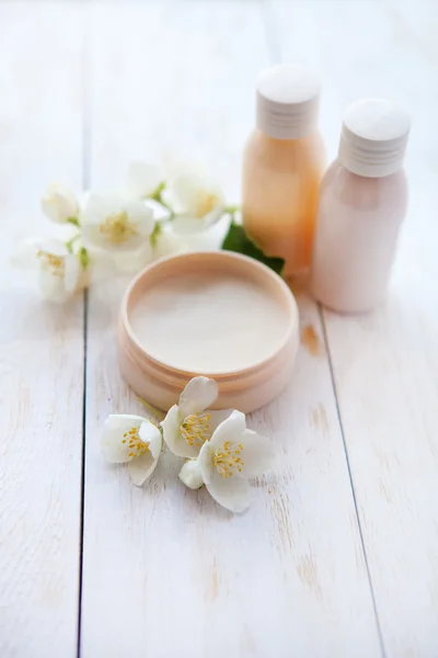 Productos de spa. crema de belleza y flor de jazmín blanco en mesa de madera blanca —  Fotos de Stock