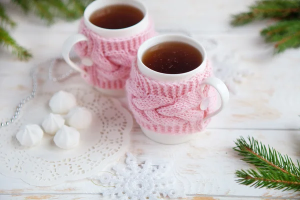 Cup of hot tea in knitted cup holder  with sweets and christmas decorations — Stock Photo, Image