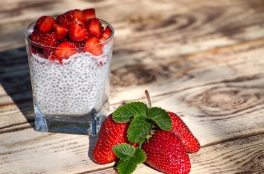 Chia puding ahşap masa üzerinde çilek ile
