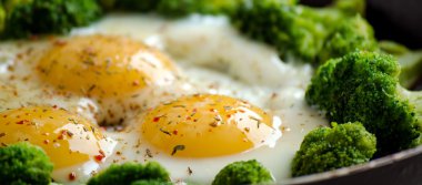 Brokoli ve baharat bir tavada ile pişmiş yumurta