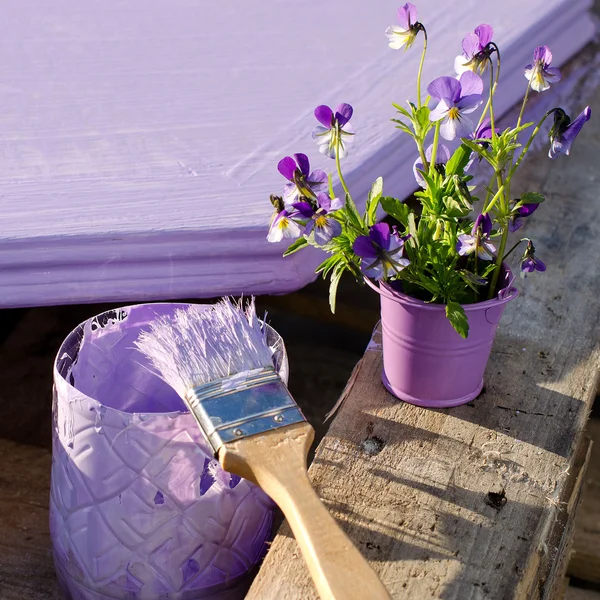 Purple paint in a jar and brush on the background of painted boa