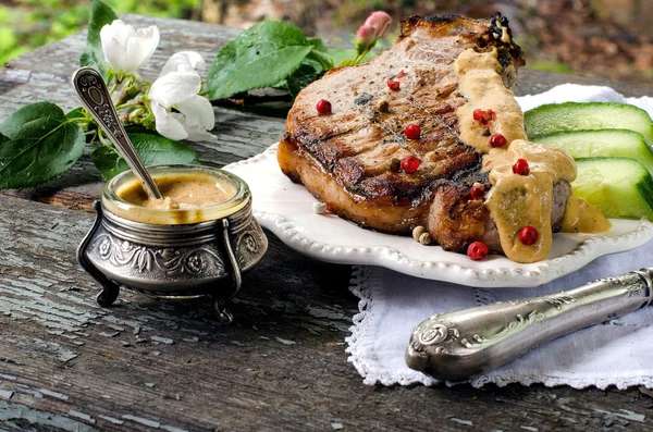 Domuz eti biftek, masada bir kavanoza hardal. Vintage tarzı.