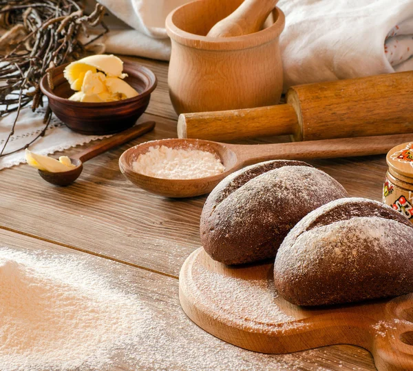 Nybakat bröd, mjöl och köksredskap — Stockfoto