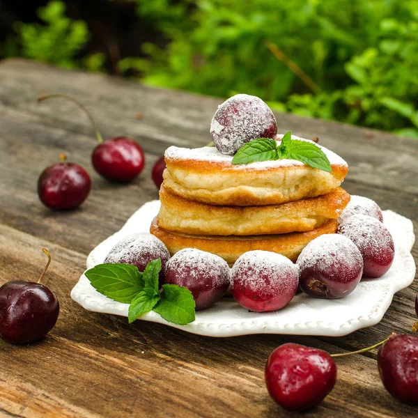 Pancakes stacked on a plate with cherries — Stock Photo, Image