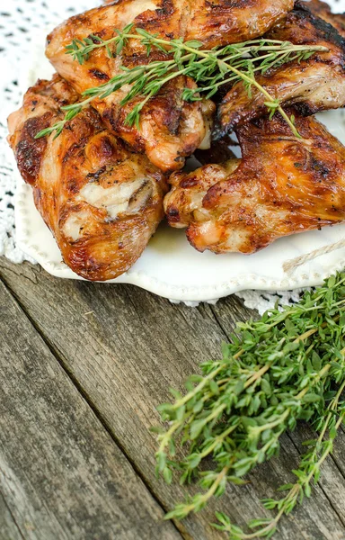 Asas de frango fritas com tomilho em uma chapa — Fotografia de Stock