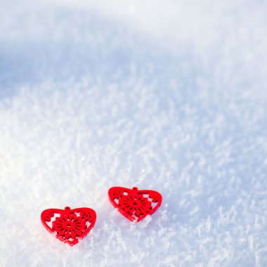 Kar bir arka plan üzerinde dekoratif kırmızı Kalpler