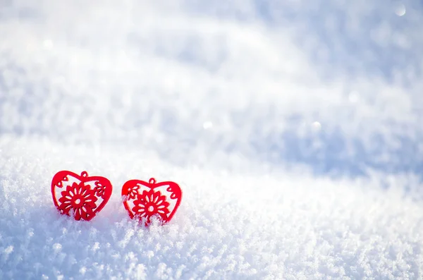Decorative red hearts on a background of snow — Stock Photo, Image