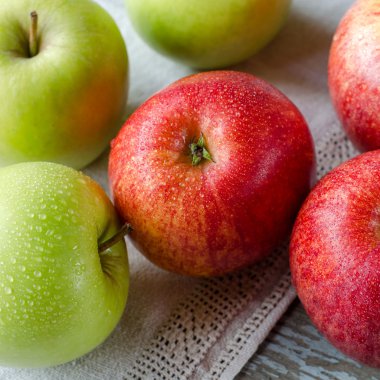 Çiy damlaları ile kırmızı ve yeşil elma.