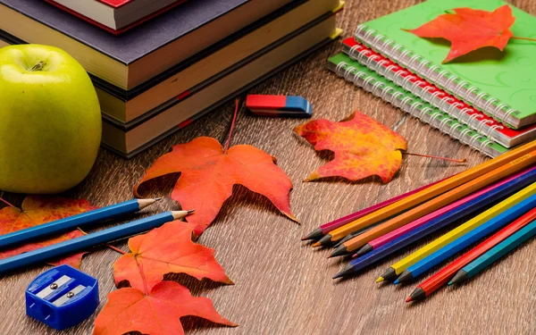 Kitap, kalem, defter ve elma bir tablo