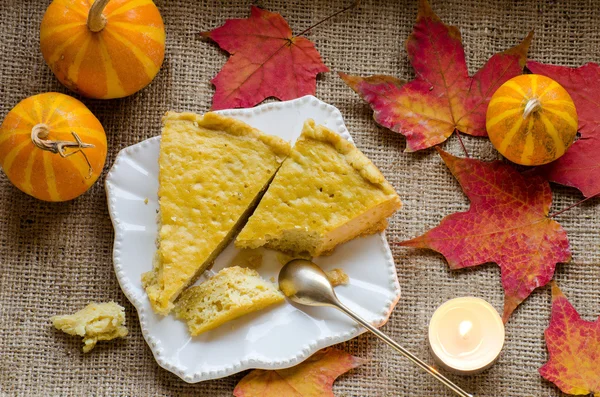 The pieces of pie on a plate, pumpkins and autumn leaves — Stock Photo, Image