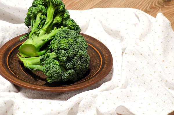 Brokoli pada piring tanah liat di atas meja — Stok Foto