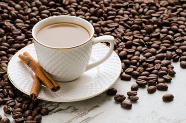 Beyaz fincan kahve çekirdekleri ve tarçın ile