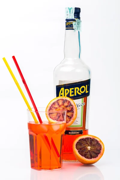 Glass of light drink and ice cube with bottle of Aperol — Stock Fotó