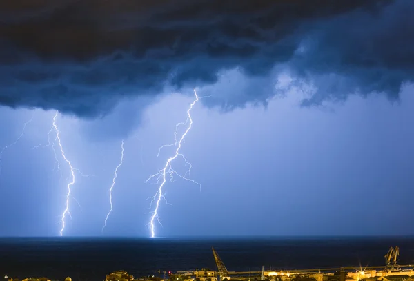 Massive cloud to ground lightning bolts hitting the horizon of city lights — Stock Photo, Image