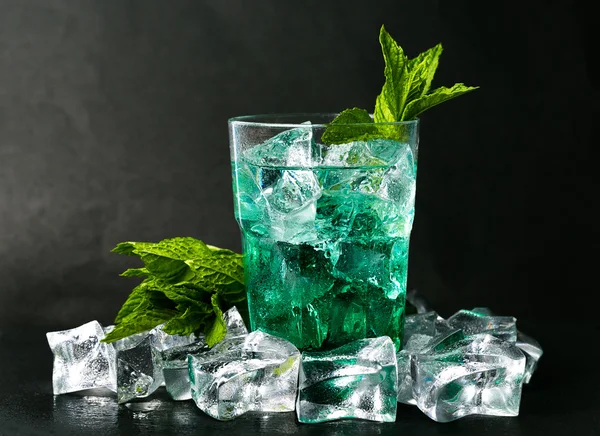 Iced green peppermint syrup with tonic water and ice cube