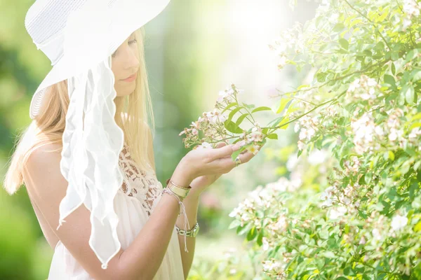 Retrato de bela mulher jovem natural com chapéu branco no jardim de rosas — Fotografia de Stock