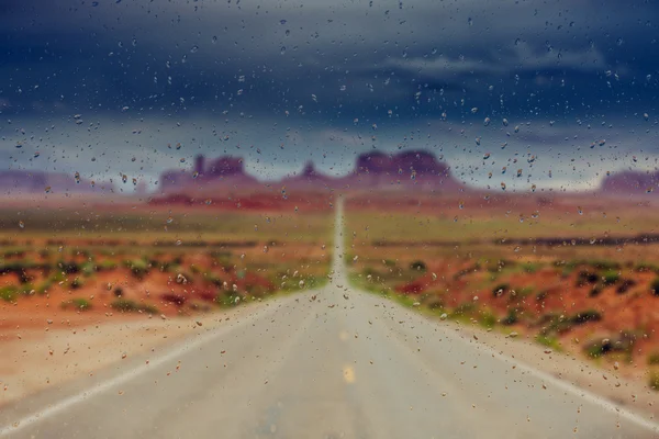 Abstract blurry background: view through the wet window Monument valley usa — Stock Photo, Image