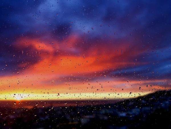 Bulanık arka plan: ıslak pencere gün batımı görünümü — Stok fotoğraf
