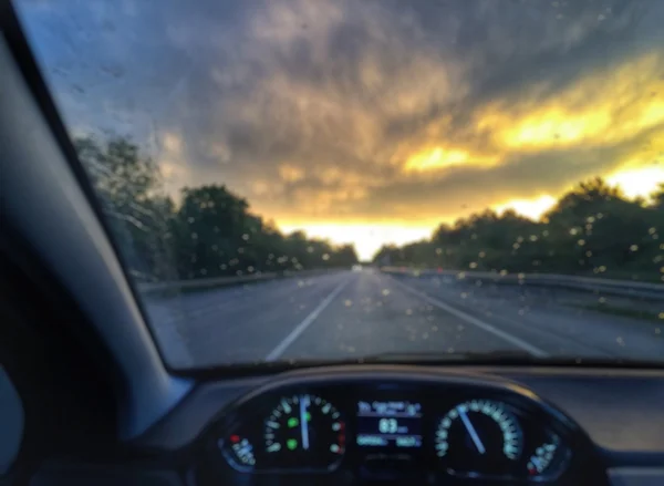 Abstract blur driving at the sunset with rain, view of dashboard — Stock Photo, Image